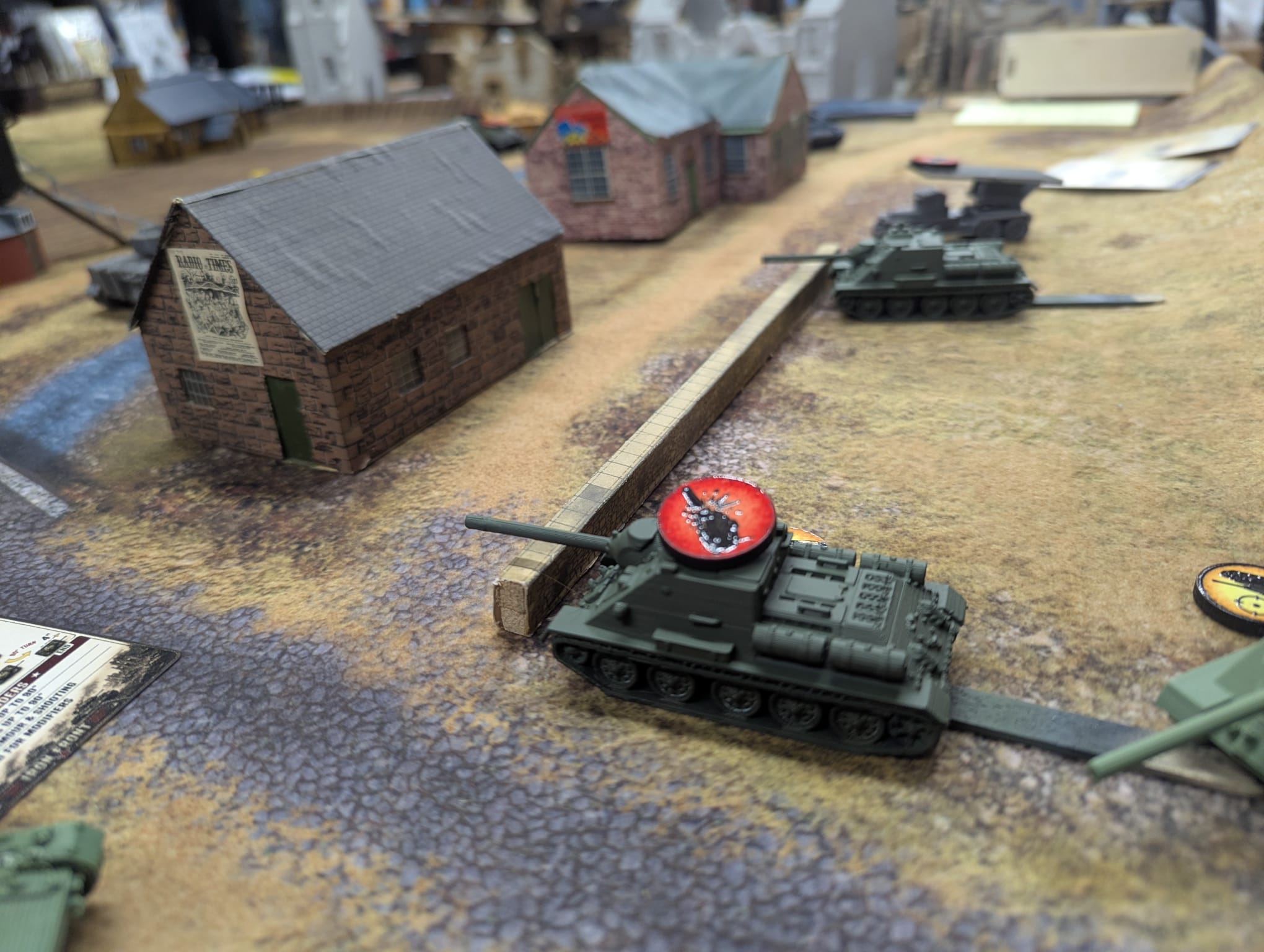 British armour advancing beside a stone building
